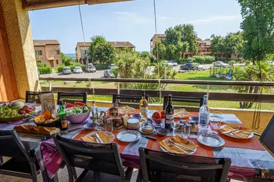 a table with food and drinks and a view of a street at A nostra casetta corsa, Carina, en bord de mer in Ghisonaccia