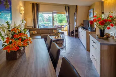 a kitchen and living room with a table and flowers at A nostra casetta corsa, Carina, en bord de mer in Ghisonaccia