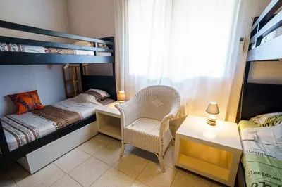 a bedroom with two bunk beds and a chair and a desk at A nostra casetta corsa, Carina, en bord de mer in Ghisonaccia