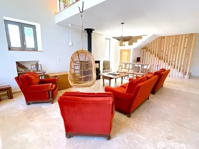 a living room with red chairs and a bird cage at L'appartement Vinosa in Aléria