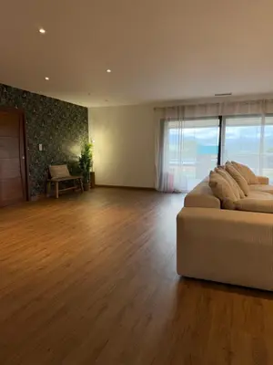 a living room with a couch and a wooden floor at Maison de campagne in Sartène