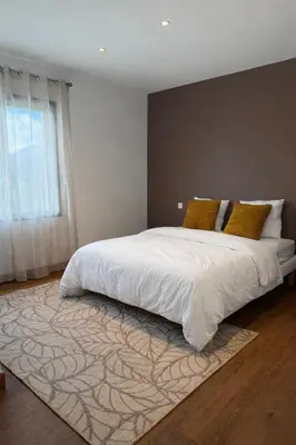 a bedroom with a large white bed with yellow pillows at Maison de campagne in Sartène
