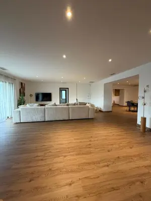 a large living room with white couches and a wooden floor at Maison de campagne in Sartène
