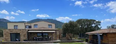 a house with mountains in the background at Maison de campagne in Sartène