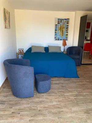 a bedroom with a blue bed and two chairs at A Stalla in Piana