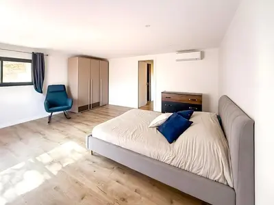 a bedroom with a bed and a desk and a chair at Villa A Muredda, 6 pers, jacuzzi, 15 min plage en voiture in Porto-Vecchio