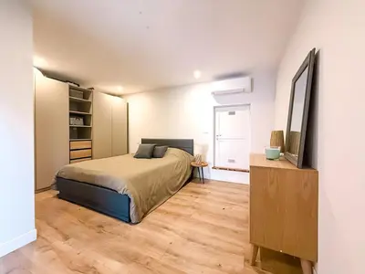 a bedroom with a bed and a flat screen tv at Villa A Muredda, 6 pers, jacuzzi, 15 min plage en voiture in Porto-Vecchio