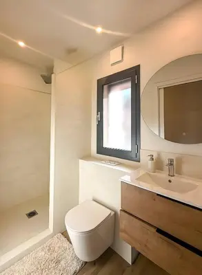 a bathroom with a toilet and a sink and a window at Villa A Muredda, 6 pers, jacuzzi, 15 min plage en voiture in Porto-Vecchio