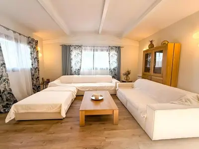 a living room with two white couches and a table at Villa A Muredda, 6 pers, jacuzzi, 15 min plage en voiture in Porto-Vecchio