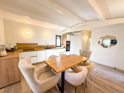 a kitchen and dining room with a wooden table and chairs at Villa A Muredda, 6 pers, jacuzzi, 15 min plage en voiture in Porto-Vecchio