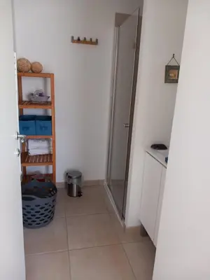 a bathroom with a door open to a room with a tile floor at T3 bord de mer corse N 138 in Linguizzetta