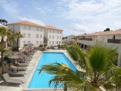 a pool with chairs and umbrellas next to a building at T3 bord de mer corse N 138 in Linguizzetta