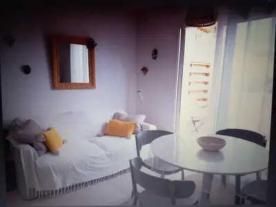 a room with a table and a couch and a table and chairs at T3 bord de mer corse N 138 in Linguizzetta