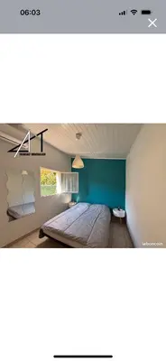 a bedroom with a bed with a blue wall at A casa Patricia in Sari Solenzara