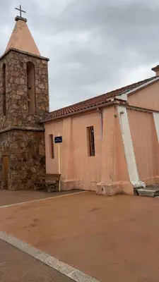 an old church with a tower and a building at A casa Patricia in Sari Solenzara
