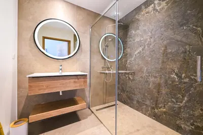 a bathroom with a shower with a sink and a mirror at Villa A Pinnata in Albitreccia