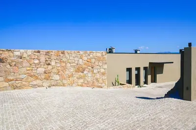 a building with a stone wall and a doorway at Villa A Pinnata in Albitreccia
