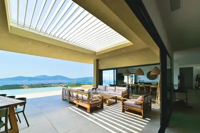 an indoor patio with a view of the ocean at Villa A Pinnata in Albitreccia