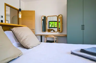 a bedroom with a white bed and a mirror at Villa A Pinnata in Albitreccia