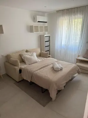 a bedroom with a large bed and a couch at New apartment, 3 bedrooms, sea view in Porto-Vecchio