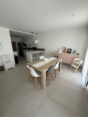 a dining room with a table and chairs in a kitchen at New apartment, 3 bedrooms, sea view in Porto-Vecchio