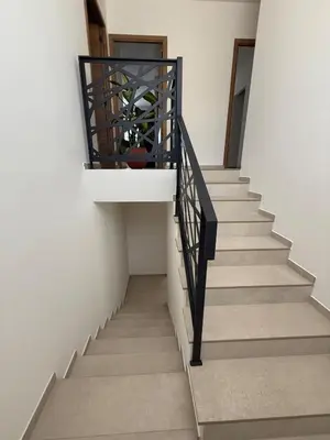 a stairway with a black railing and a stair case at New apartment, 3 bedrooms, sea view in Porto-Vecchio