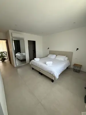 a bedroom with a large bed and a mirror at New apartment, 3 bedrooms, sea view in Porto-Vecchio