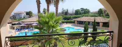 a view of a resort pool from a balcony at Appartement avec piscine en Bord de Mer - Corse in Linguizzetta