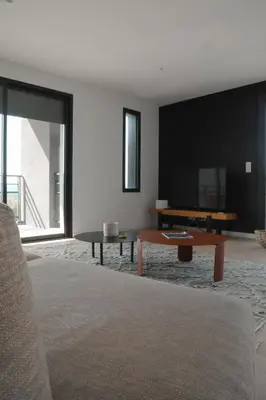 a living room with a table and a tv at So Home in Porto-Vecchio