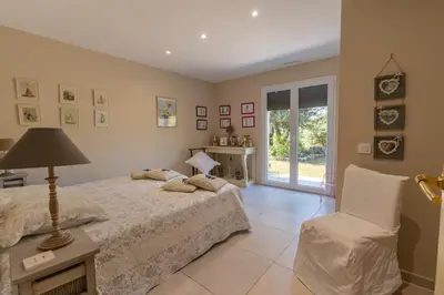 a bedroom with a bed and a chair at Villa avec piscine privée in Serra-di-Ferro