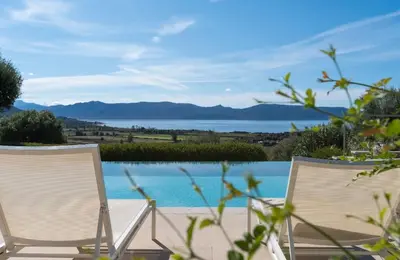 two chairs sitting next to a swimming pool at Villa avec piscine privée in Serra-di-Ferro