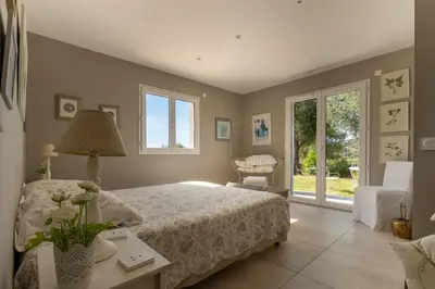 a bedroom with a bed and a chair and a window at Villa avec piscine privée in Serra-di-Ferro