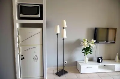 a living room with a couch and a kitchen at Studio piscine et plage in Cervione