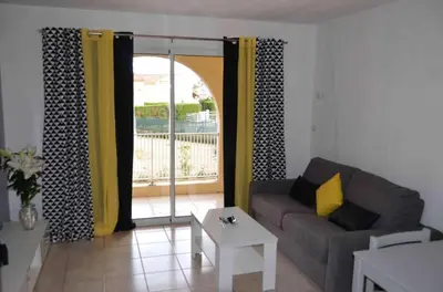 a living room with a couch and a table at Studio piscine et plage in Cervione