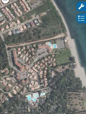 an aerial view of a city with houses and the ocean at Studio piscine et plage in Cervione