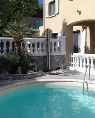 a swimming pool in front of a house at Appartement Sole e Mare in Furiani