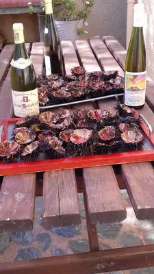 a table with two plates of lobsters and two bottles of wine at Appartement Sole e Mare in Furiani