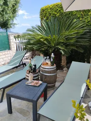a patio with a table and chairs and a barrel at Appartement Sole e Mare in Furiani