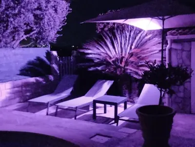 a group of chairs and an umbrella at night at Appartement Sole e Mare in Furiani