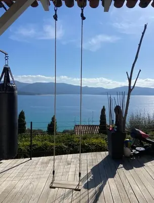 a swing on a deck with a view of the water at Superbe appartement type mini villa vue mer panoramique in Olmeto