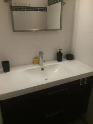 a bathroom with a white sink and a mirror at Superbe appartement type mini villa vue mer panoramique in Olmeto