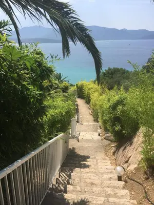 a stone path with a fence and the ocean at Superbe appartement type mini villa vue mer panoramique in Olmeto