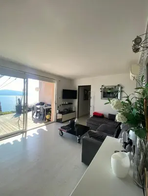 a living room with a couch and a view of the ocean at Superbe appartement type mini villa vue mer panoramique in Olmeto