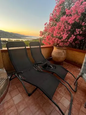 two chairs sitting on a balcony with pink flowers at Mini-Villa Nacres - Vue mer - clim- Wi-fi -Favone in Conca