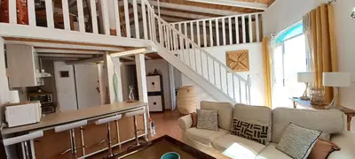 a living room with a couch and a staircase at Mini-Villa Nacres - Vue mer - clim- Wi-fi -Favone in Conca