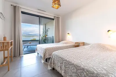 a hotel room with two beds and a large window at La Vista - Climatisé vue mer in Grosseto-Prugna