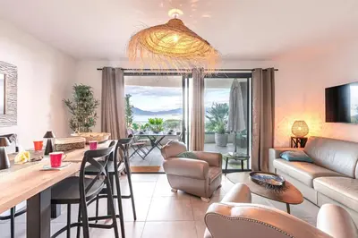 a living room with a table and chairs and a dining room at La Vista - Climatisé vue mer in Grosseto-Prugna