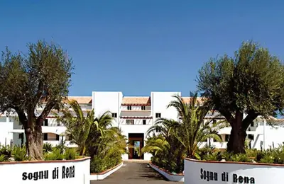 a large white building with trees in front of it at Appartement en bord de mer in San-Nicolao