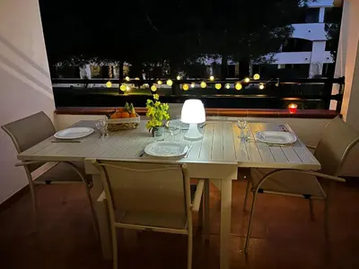 a wooden table with chairs and a table lamp on it at Appartement en bord de mer in San-Nicolao
