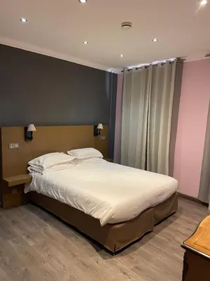 a bedroom with a large bed with white sheets at Chambre Le Chevalblanc